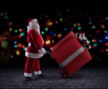 Santa claus delivers a big gift for Christmasの写真素材