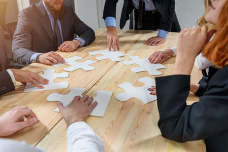 Teamwork of partners connect puzzle pieces as integration and startupの写真素材