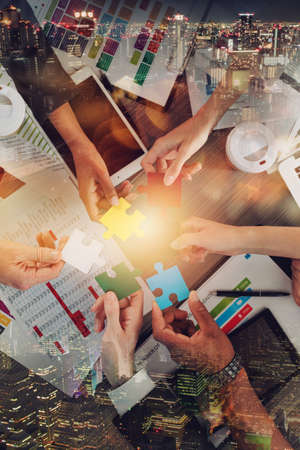 Teamwork of partners connect puzzle pieces as integration and startupの写真素材