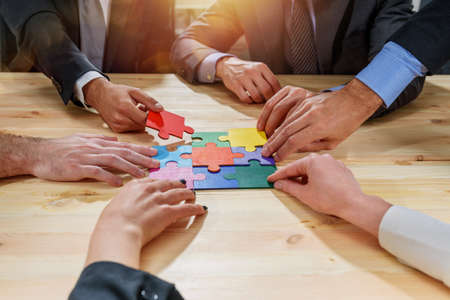 Teamwork of partners connect puzzle pieces as integration and startup