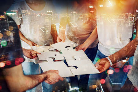 Teamwork of partners connect puzzle pieces as integration and startupの写真素材