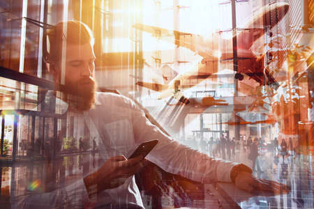 Businessman works in office with a smartphone connected on internet networkの写真素材
