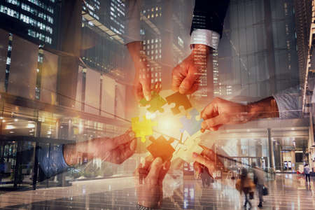 Teamwork of partners connect puzzle pieces as integration and startup