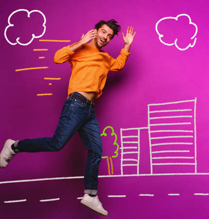 Happy man jumps against a purple backgroundの写真素材