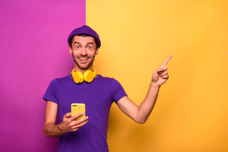 Man with smartphone is happy and indicates something
