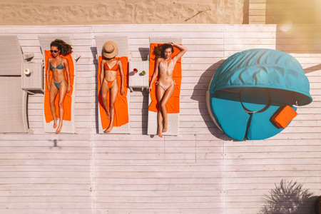 Group of friends in swimsuit drink a cocktail in a swimming poolの写真素材