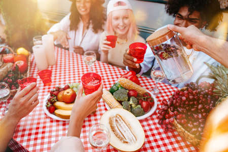Friends have a picnic with a camper in a sunny dayの写真素材
