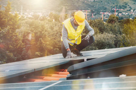 Workers assemble energy system with solar panel for electricityの写真素材