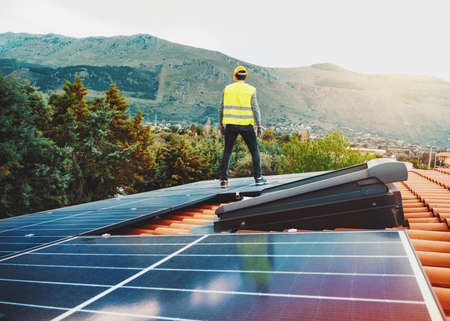 Workers assemble energy system with solar panel for electricityの写真素材