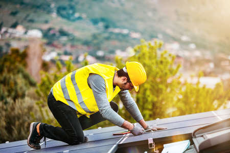 Workers assemble energy system with solar panel for electricity