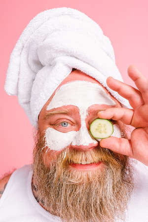 Man with beard acts like a woman and has fun with a facial maskの写真素材