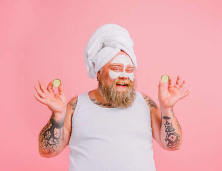 Man with beard acts like a woman and has fun with a facial maskの写真素材