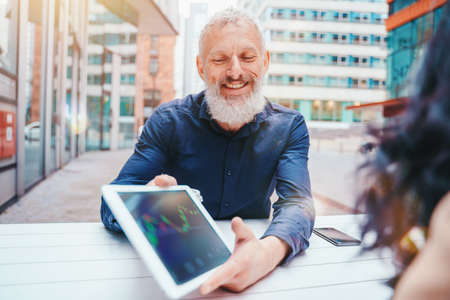 Businessman shows trading stock market chart on a tabletの写真素材