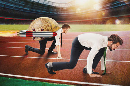 Businessman slow like a snail runs fast thanks to rocketsの写真素材