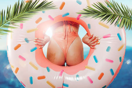 Sexy woman with inflatable donut ready for the sumerの写真素材
