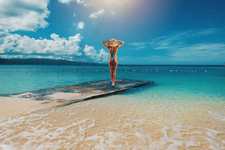 Woman relaxing under the sun at the crystalline seaの写真素材