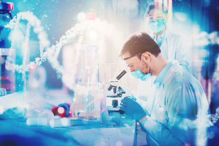 Doctor in the laboratory analyzes samples of codiv-9 under a microscopeの写真素材