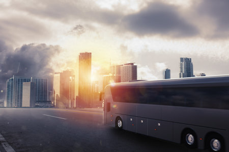Black bus moving on the road in a cityscape at sunsetの写真素材