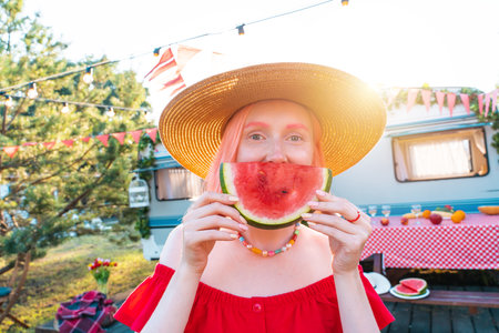 Woman eat fresh watermelon during a picnicの写真素材