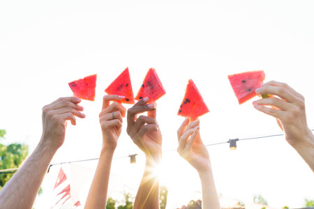 Group of friends eat fresh watermelon togetherの写真素材