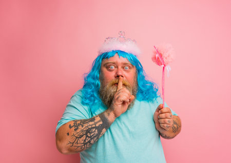 Fat serious man with tattoos acts like a magical fairyの写真素材