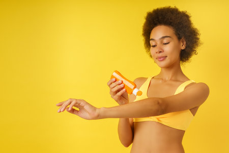 Woman girl spreads sunscreen to protect herself from the sunの写真素材