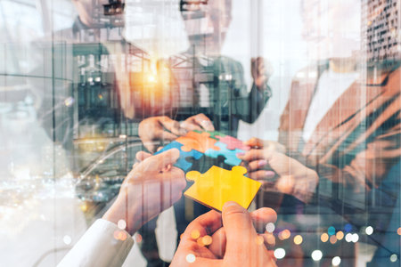 Teamwork of partners connect puzzle pieces as integration and startupの写真素材