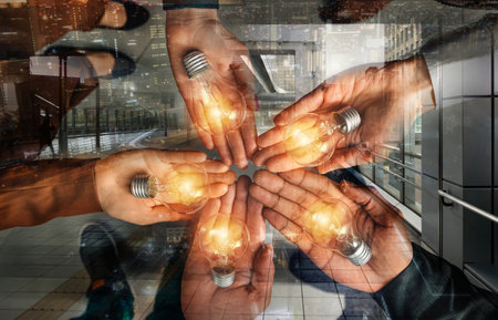 Teamwork and brainstorming concept with businessmen that share an idea with a lampの写真素材