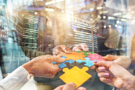 Teamwork of partners connect puzzle pieces as integration and startupの写真素材