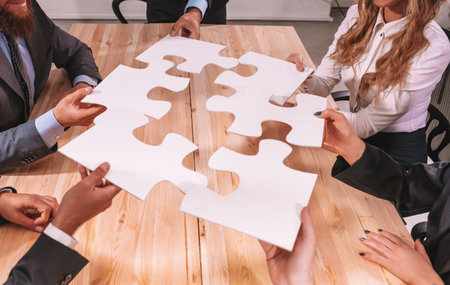 Teamwork of partners connect puzzle pieces as integration and startupの写真素材