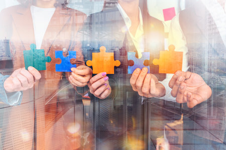 Teamwork of partners connect puzzle pieces as integration and startupの写真素材