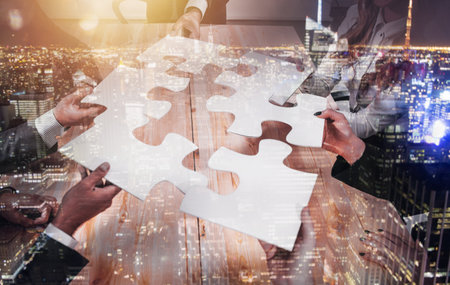 Teamwork of partners connect puzzle pieces as integration and startupの写真素材