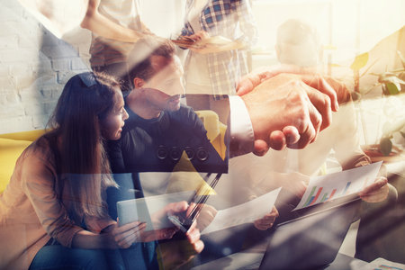 Team of workers reaches an agreement. Double exposure with light effectの写真素材