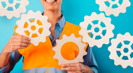 Engineer woman joins pieces of gears as concept of partnership and integrationの写真素材