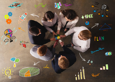Business people join puzzle pieces in office. Concept of teamwork and partnershipの写真素材