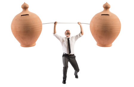 Powerful and determined businessman trains with a barbell with piggy banksの写真素材