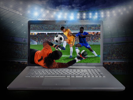 Live streaming of a soccer player match on a laptopの写真素材