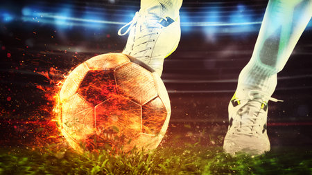 Close up of a soccer scene with player kicking a fiery ball with powerの写真素材