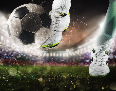 Football scene with close up of a soccer shoe hitting the ball with powerの写真素材