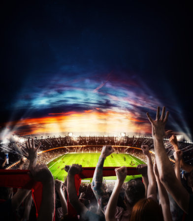 Football scene at night match with with cheering fans at the stadiumの写真素材