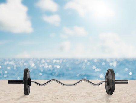 Curved barbell in a sunny and clean beachの写真素材