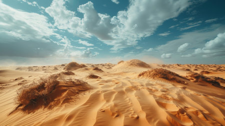 Rippled desert dunes covered in swirling sand beneath a dramatic skyの素材