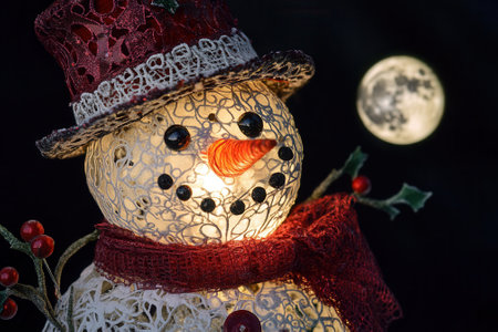 Glowing snowman ornament shines under full moon on christmas eveの素材