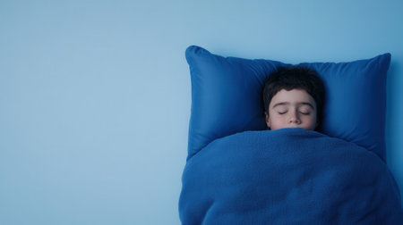 Caucasian child sleeping peacefully in blue bed with blanket and pillowの素材