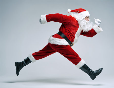 Santa Claus running energetically in a vibrant red suit during festive season preparationsの素材