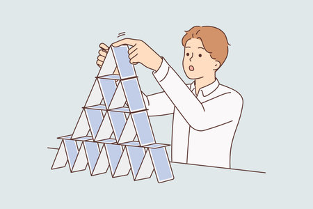 Concentrated man makes pyramid of playing cards symbolizing fragile business structureのイラスト素材