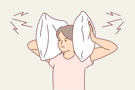 Irritated woman covers ears with pillow so as not to hear noise from neighbors who are having partyのイラスト素材