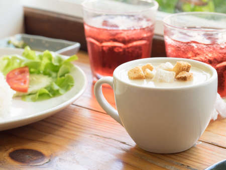 Cream soup and bread toasted on wooden tableの写真素材