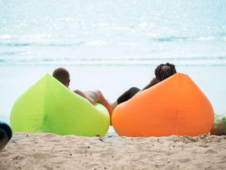 Man and woman laying on air sofa at Phuket beach Thailandの写真素材