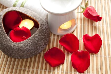 Spa Concept  Rose petals, aroma candles on bamboo matsの写真素材